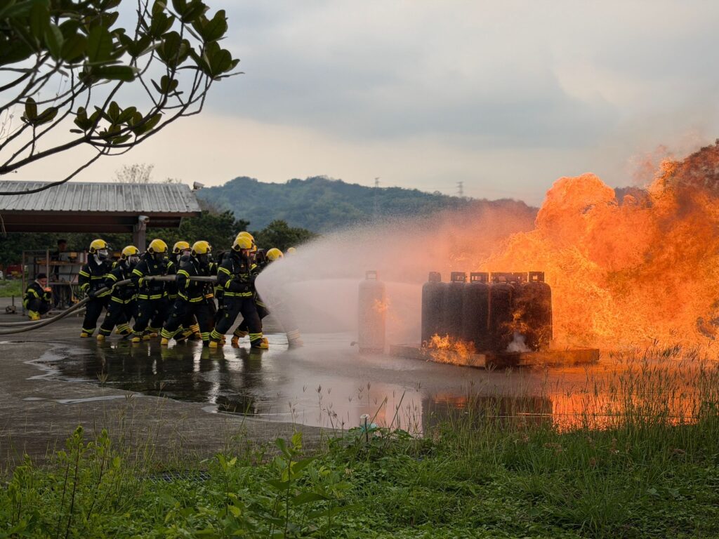 Fire drill training exercise with team extinguishing a controlled fire